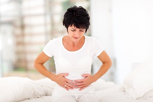 mid age woman having stomach pain at home